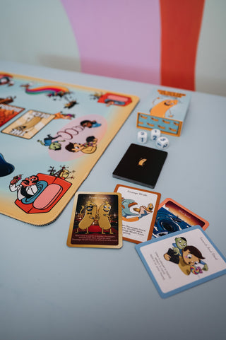 The Golden Sausage Play Mat in use with cards and the game box on the table