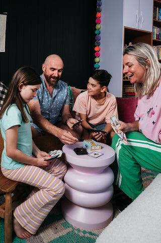 Family playing cards around a small table